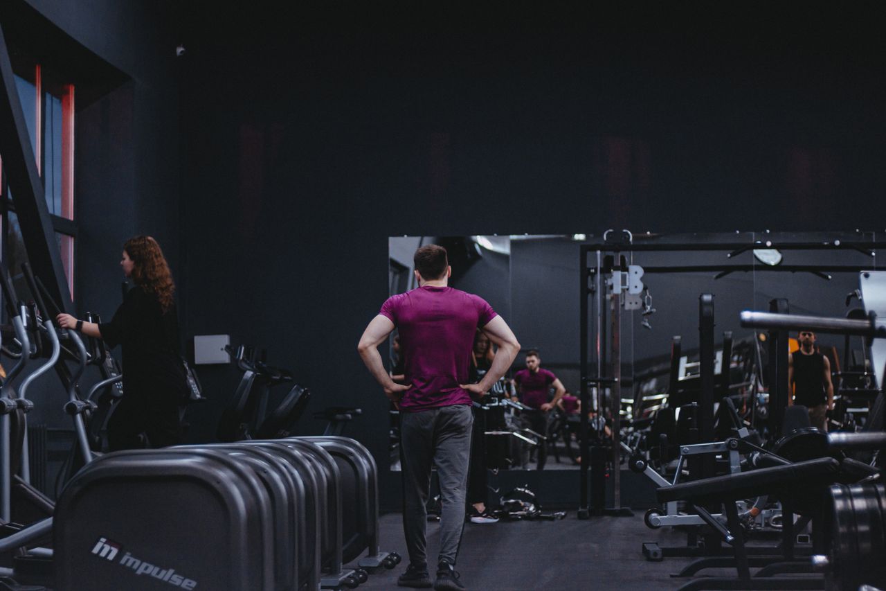 Man in a gym with fitness equipment, highlighting a healthy lifestyle.